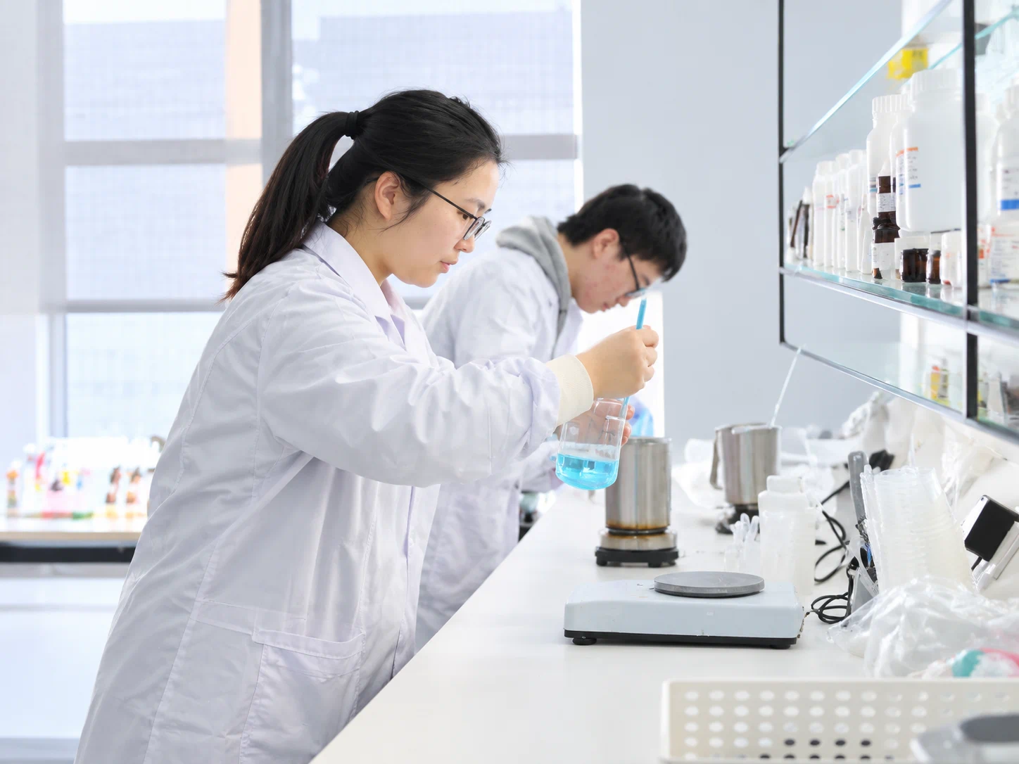 Laboratory staff evaluating fragrance liquid for molded air freshener development