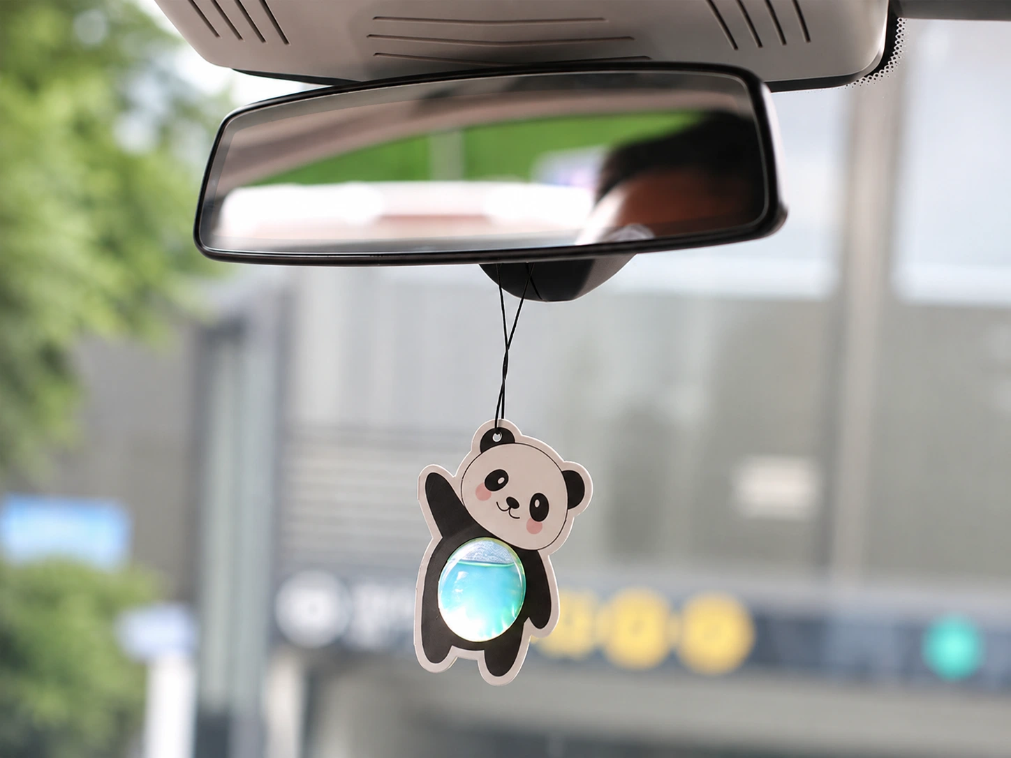 Hanging membrane air freshener suspended from a car rearview mirror
