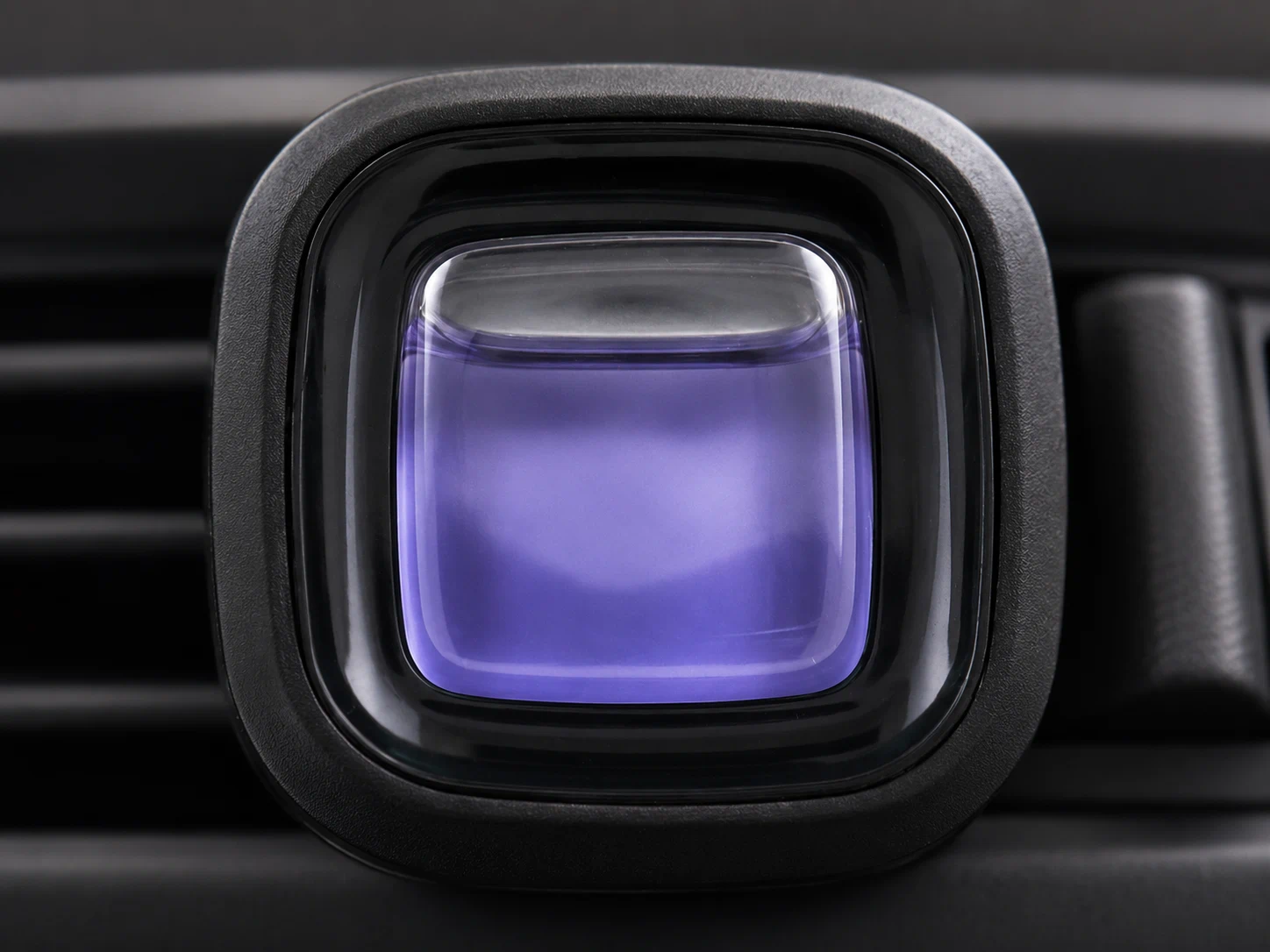 Membrane air freshener installed on a car air vent showing the fragrance chamber and housing