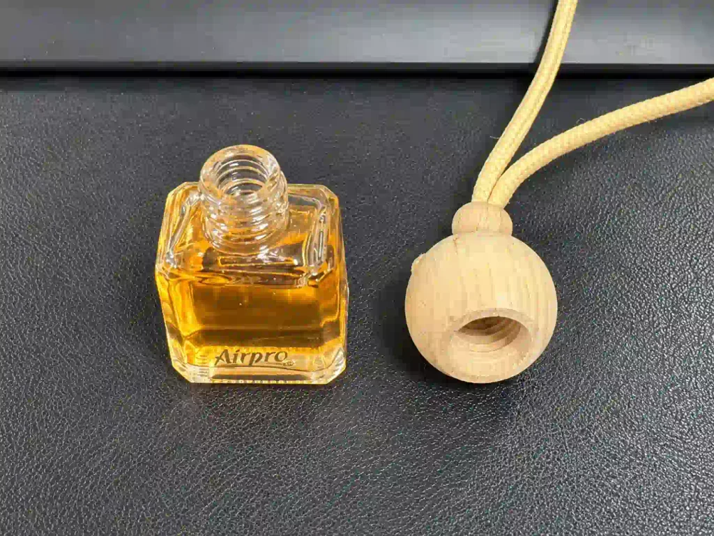 Glass bottle and wooden cap components of a hanging air freshener